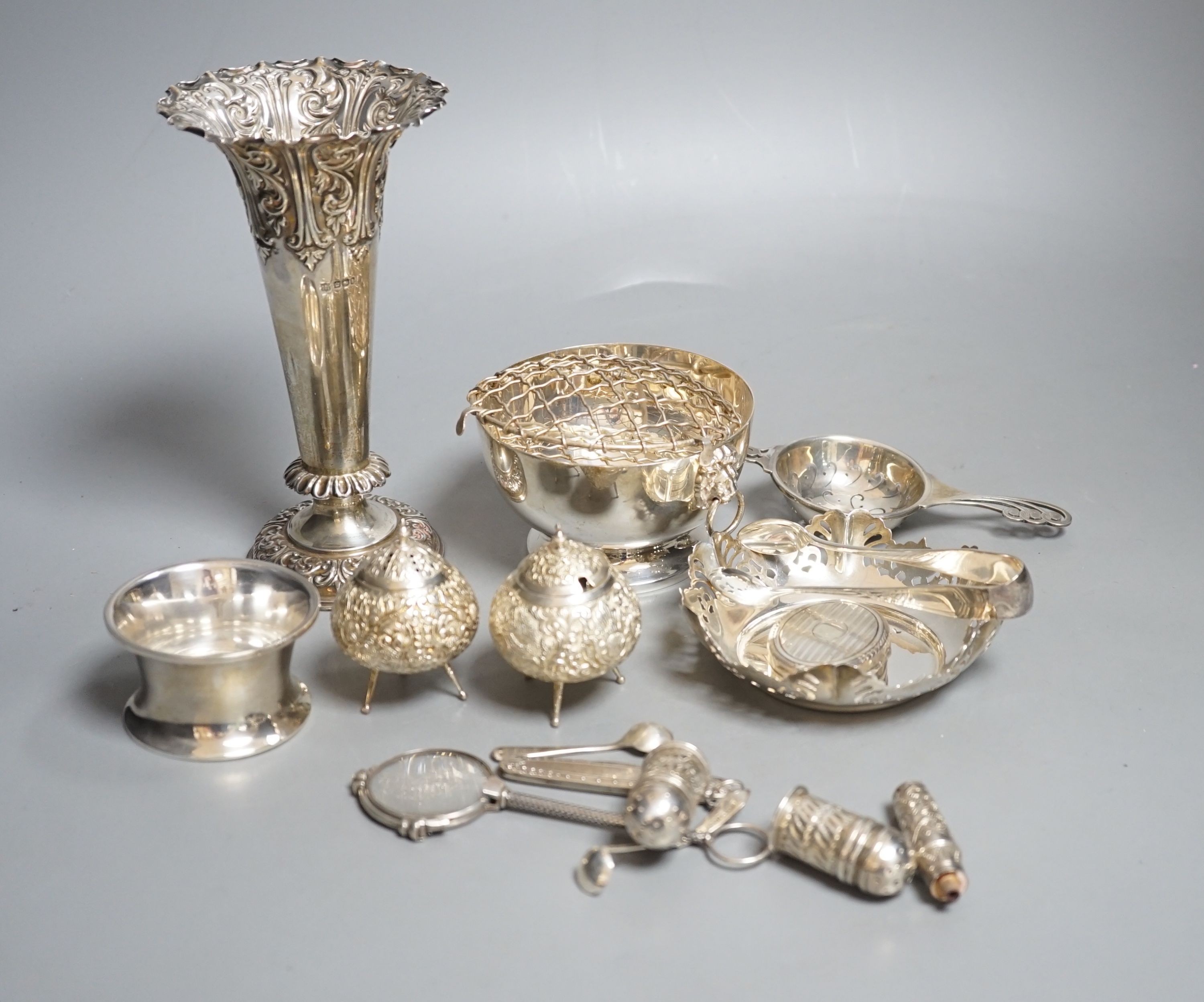 A late Victorian repousse silver vase, Sheffield, 1900, 17.9cm, loaded, a silver tea strainer and stand, a modern silver rose bowl, sterling dish, four condiments including two silver and six other items.